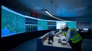 Engineers monitoring Nigeria's national electricity grid in a modern SCADA control room with real-time transmission data on screens