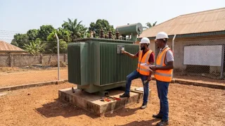 Nigerian electrical engineers inspecting an oil-immersed distribution transformer substation before NEMSA commissioning certification