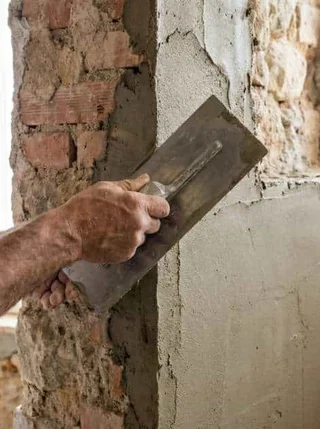 Plasterer applying plaster to a wall inside a Spanish property