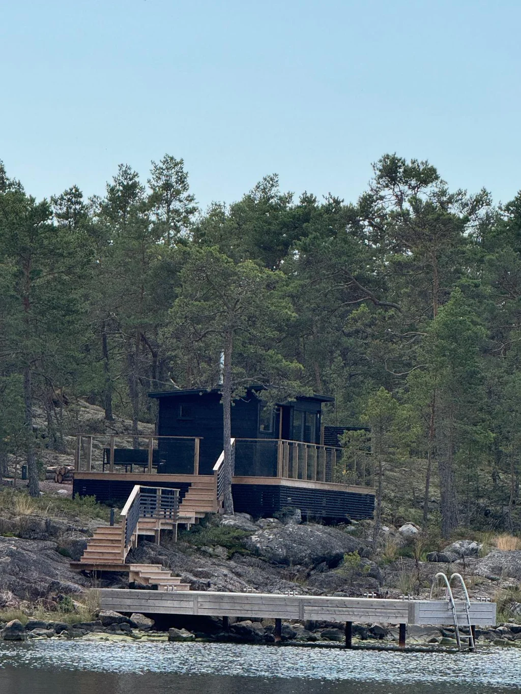 Svart villa med terrass och en ny brygga