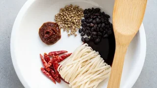 Mapo tofu — soft tofu cubes in deep brick-red doubanjiang sauce with minced pork, Sichuan peppercorns, and chilli oil