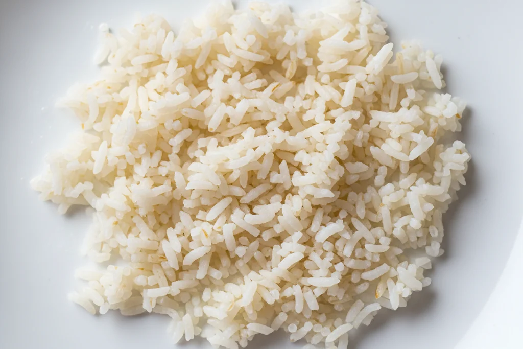 Extreme macro close-up of dry separated day-old jasmine rice grains on a white surface